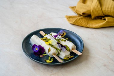 Ev yapımı Hint Rajasthani Kulfi Dondurması Stick / Kesariya ve Pistachio ve Yenilebilir Çiçekler. Geleneksel Tatlı.