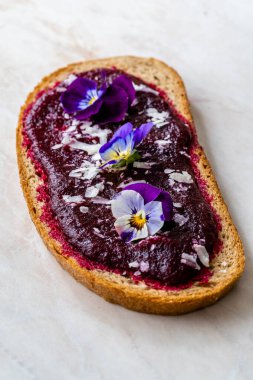 Pancar ezmesi, tost ekmeği, parmesan peyniri ve yenilebilir çiçek ve pancar soslu vejetaryen jambonu. Sağlıklı Organik Gıda.