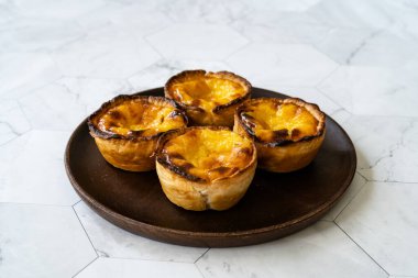 Pasteis de Nata veya Belem Tart. Tahta tabakta yumurta, tarçın, şeker ve un ile yapılmış Portekiz kreması. Geleneksel Tatlı.