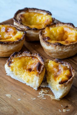 Pasteis de Nata veya Belem Tart. Tahta tabakta yumurta, tarçın, şeker ve un ile yapılmış Portekiz kreması. Geleneksel Tatlı.