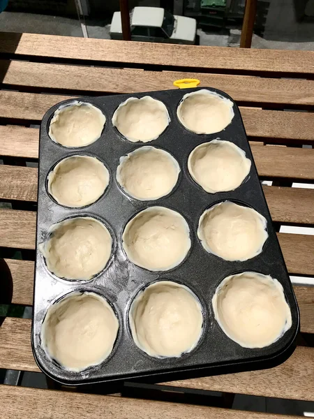 パスタを作ると調理するDe NataまたはBelem Tart マフィントレイ カップケーキ型の卵 シナモン シュガー 小麦粉で作られたポルトガルのカスタード 伝統的なデザート — ストック写真
