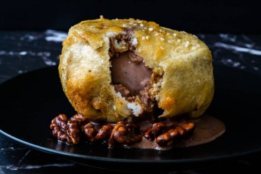 Çikolatalı kızarmış dondurma ve siyah tabakta kavrulmuş ceviz. Geleneksel Organik Tatlı.