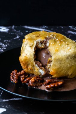 Çikolatalı kızarmış dondurma ve siyah tabakta kavrulmuş ceviz. Geleneksel Organik Tatlı.