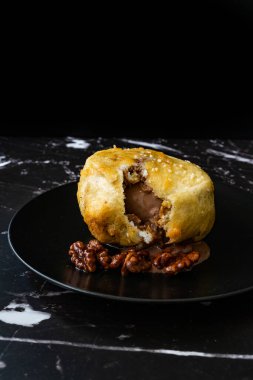 Çikolatalı kızarmış dondurma ve siyah tabakta kavrulmuş ceviz. Geleneksel Organik Tatlı.