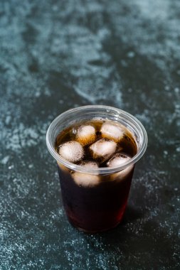 Plastik bardakta buz ve yaz için samanla soğuk demlenmiş kahveyi götür..