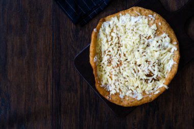 Geleneksel Lango / Langosh aslında mayadan yapılmış, üzerinde parmesan peyniri ve yumuşak krem peynir / Pisi bulunan Macar kızarmış gözlemeleridir. Yemeye hazır..