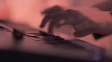 Piyanistler eller üzerinde elektronik bir synthesizer oynanır