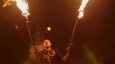 Ateşli jetleri zemin karşı bir alev makinesi sallayarak bir adam. Eylem slowmotion olarak