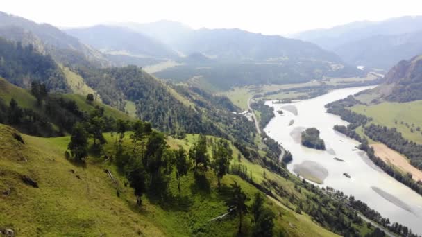 Punto de vista aéreo. Panorama horizontal de las montañas verdes de Altai sobre el telón de fondo del paisaje de un río de montaña y un valle con vida silvestre — Vídeo de stock