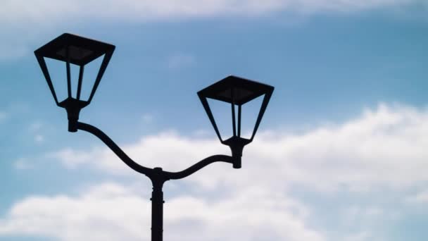 Streetlight stays on at moving blue clouds — Stock Video