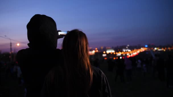 Chica y chico en ropa negra, fotografiado en la noche del teléfono de la ciudad — Vídeos de Stock