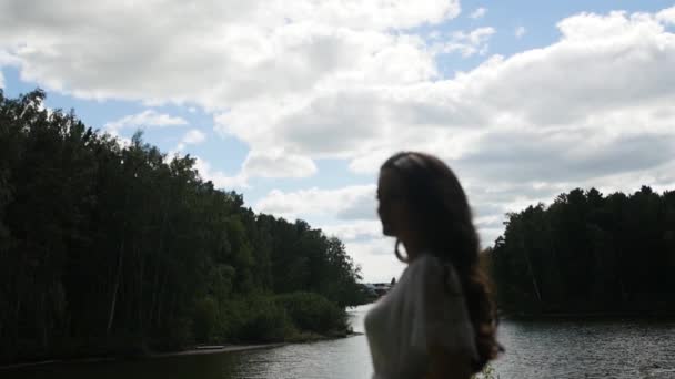 La silueta de una chica contra el cielo nublado — Vídeos de Stock