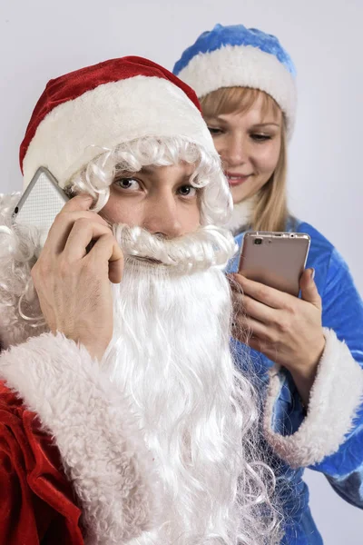 Papai Noel e donzela de neve segurando telefones — Fotografia de Stock