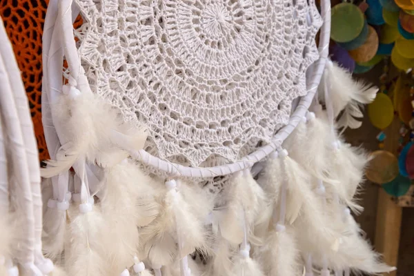 Dreamcatcher with feathers, white tribal symbol.