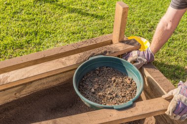 Çöpleri temizlemek için toprağı bir bahçe süzgecinden geçirmek.
