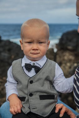 Erkek yelek açık resmi gri elbiseli gülümseyen sevimli küçük bebek