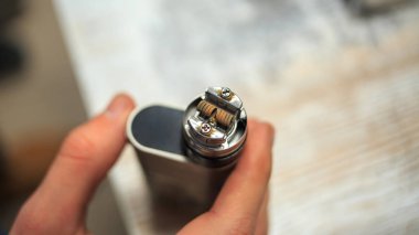 Elektronik cigarettein erkek elinde. Mekanik mod. Biter.