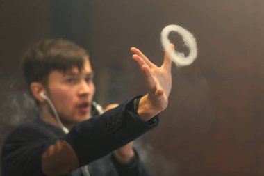 Genç yakışıklı beyaz adam Buhar Yüzükler izin verdi. Vaping.