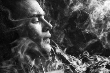 Genç yakışıklı beyaz adam admiting puffs üzerinden elektronik sigara Buhar olduğunu. Vaping. Genç müzik. Siyah ve beyaz fotoğraf.