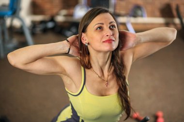 Genç güzel kız bir sarı beyaz ve gri spor takım elbise eğitim aparatı fitness Club egzersizleri yapıyor.