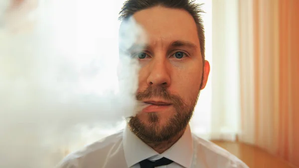 Vape. Młody śmieszne biały biznesmen broda i wąsy emituje puff steam z elektronicznych papierosów w kuchni. Z bliska. — Zdjęcie stockowe
