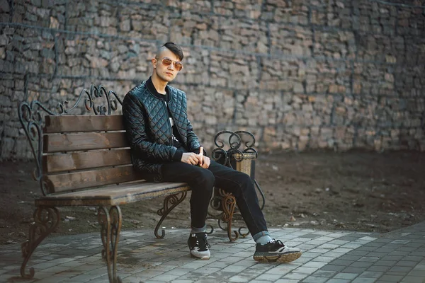 Vape입니다. 젊은 잘생긴 남자는 전자 담배는 벤치에 앉아 있다. 라이프 스타일. — 스톡 사진