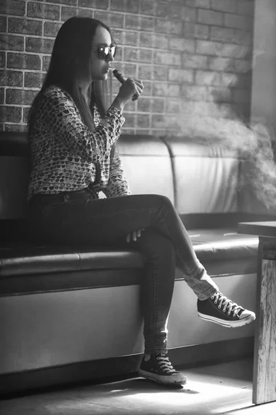 Vape. Menina branca bonito jovem em óculos de sol está admitindo sopros de vapor do cigarro eletrônico . — Fotografia de Stock