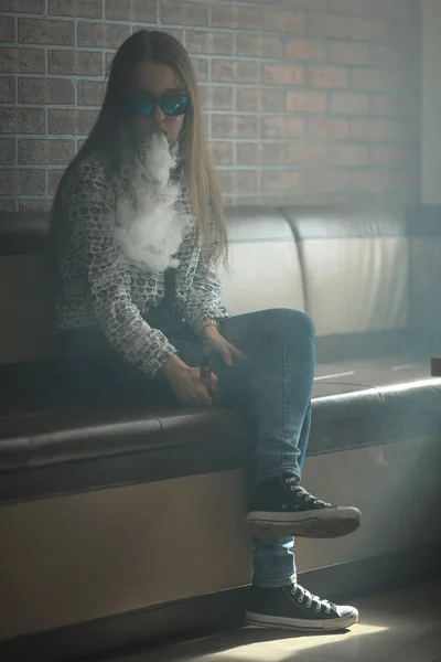 VAPE. Mladý pohledný bílá dívka v sluneční brýle se hlásíme obláčky páry z elektronické cigarety. — Stock fotografie