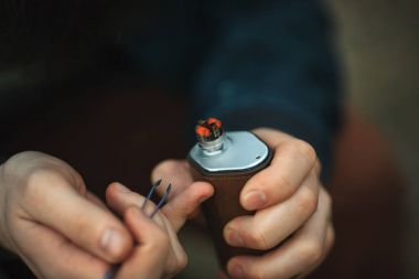 Vape. Elektronik sigara erkek elinde. Akkor bobinler.