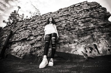 Güzel genç. Eski yıkılan tuğla duvara yakın poz kıvırcık saçlı genç ve güzel bir beyaz kız açık portresi. Siyah ve beyaz.