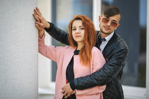 Verliefde paar. Knappe jongen en mooi meisje poseren tegenover moderne stedelijke achtergrond. — Stockfoto