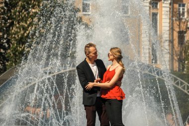 Güneşli bir çeşme yanındaki aşık Çift.