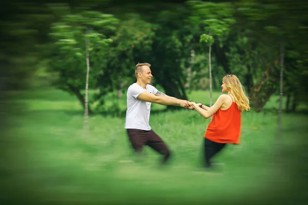 Η αγάπη ζευγάρι είναι ενεργοποιημένη σε έναν χορτοτάπητα στο πάρκο της πόλης. Η αγάπη σε κίνηση. Θολή. — Φωτογραφία Αρχείου