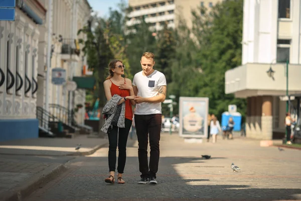 Egy szerető pár séták mellett egy városi utca, egy napsütéses nyári napon. Fiatal fiú és lány. — Stock Fotó