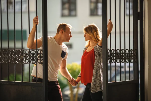Νεαρό ζευγάρι που υπάγονται στην αγάπη κοντά σε ένα vintage Μεταλλική πύλη το καλοκαίρι. Νεαρό αγόρι και κορίτσι. — Φωτογραφία Αρχείου