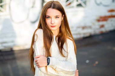 Sonbahar modeli. Sonbaharda güneşli bir günde sokakta derisi sorunlu beyaz, beyaz, genç bir kız. Kapat..