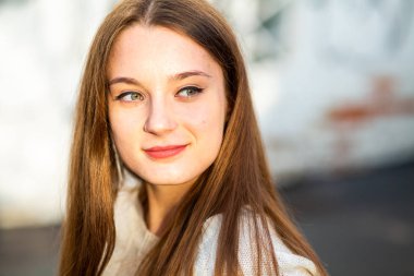 Sonbahar modeli. Sonbaharda güneşli bir günde sokakta derisi sorunlu beyaz, beyaz, genç bir kız. Kapat..