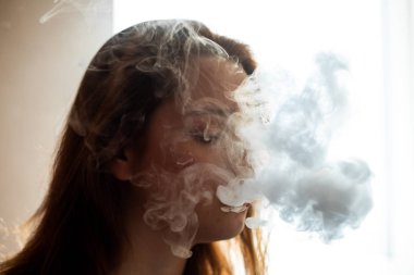 Derisi sorunlu bir genci buharlaştırmak. Barda sigara içen hoş bir kızın portresi. Kötü alışkanlık sağlığa zararlıdır. Vestiyer etkinliği.