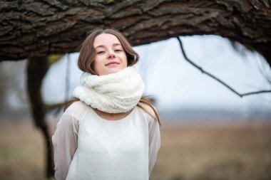 Duygusal fotoğraf. Soğuk sonbahar havasında beyaz eşarplı kedi gözlü beyaz beyaz beyaz kız. Kapat..