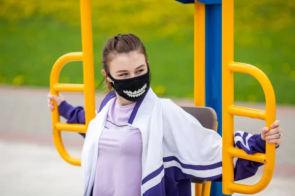 Govd 黒いマスクの若い白人の10代の少女は パンデミックの間 ストリートスポーツのグラウンドでスポーツをするために行きます ヨーロッパのコロナウイルス ストック写真