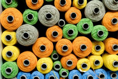 Makaralar üzerinde geleneksel dokuma dokuma için kullanılan renkli iş parçacığı yığınları