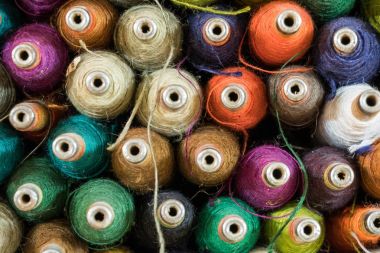 Makaralar üzerinde geleneksel dokuma dokuma için kullanılan renkli iş parçacığı yığınları