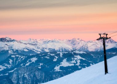 ön planda bir teleferik ile akşam günbatımı gökyüzü ve kış dağ manzara
