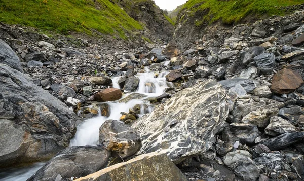 small creek and waterfall in the mountain outdoors of the southeastern Swiss Alps