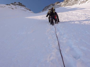 erkek aşırı kayakçı dik Kuzey yüz güzel kış gününde dar verdi üst ve yüksek dağ en yüksek zirvesine doğru yolda tırmanıyor