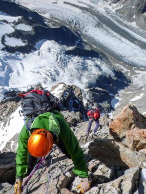 yüksek dağ Zirvesi ile büyük buzul kadar aşağıda kapalı rappelling iki dağcılar