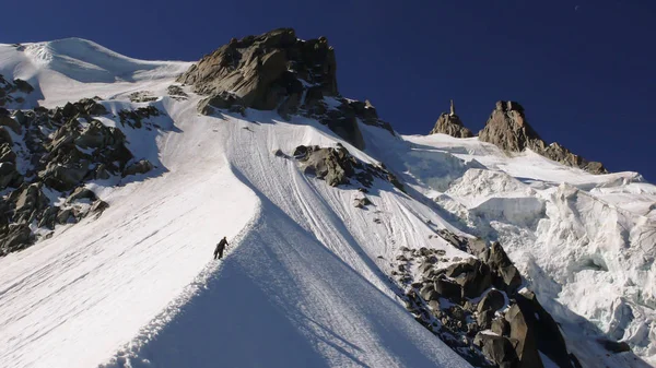 mountain climber and mountain guide on a narrow ridge on the Frendo Pillar in the French Alps near Chamonix