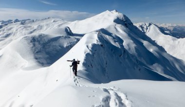 aşırı kayakçı erkek backcountry Kayak tur zirvesinde giderken İsviçre Alpleri'nde dar ve savunmasız sırt üzerinde
