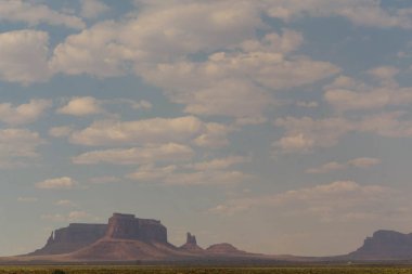 Monument Valley manzara mavi gökyüzü ile beyaz bulutlar altında