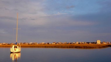 su ve Güney Carolina kıyılarının bariyer Adası creekside sularda koruluklar ön planda bir yelkenli ile güzel günbatımı ayarına